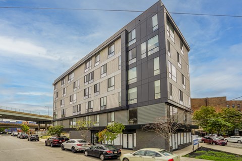 an apartment building on a city street with cars parked